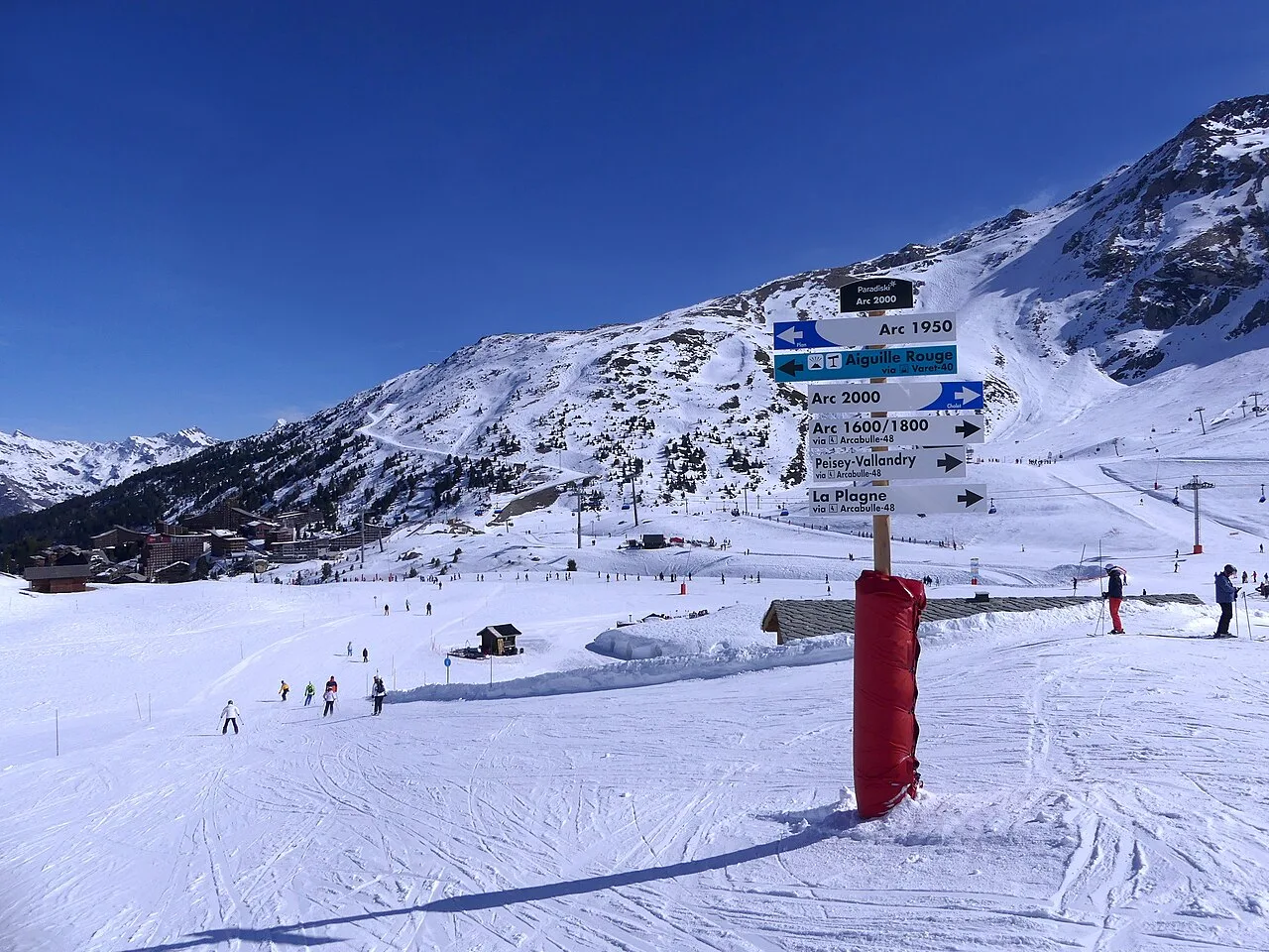 Direction signs at a snowy piste junction in Les Arcs