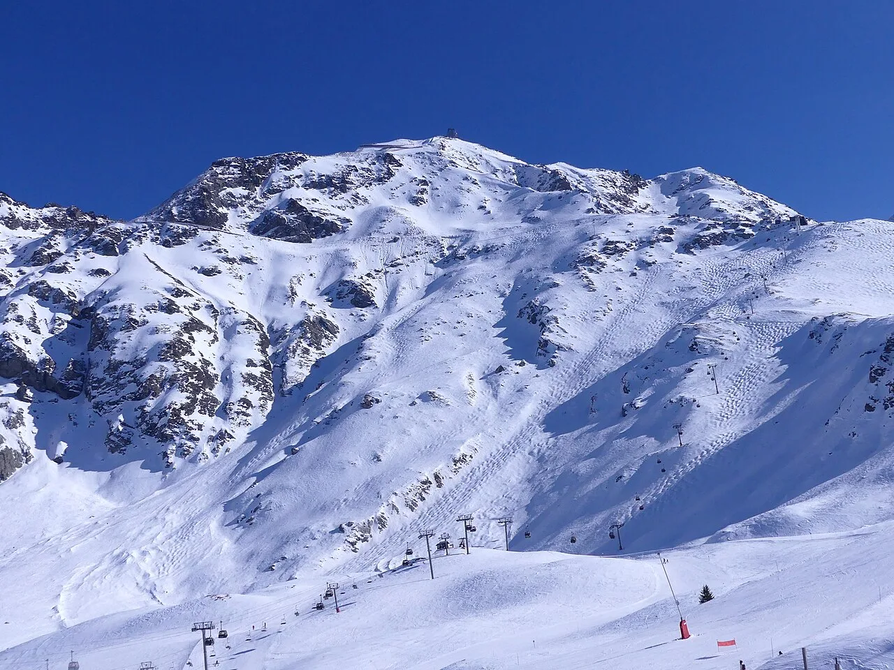 Aiguille Rouge above snowy slopes and ski lifts in Les Arcs